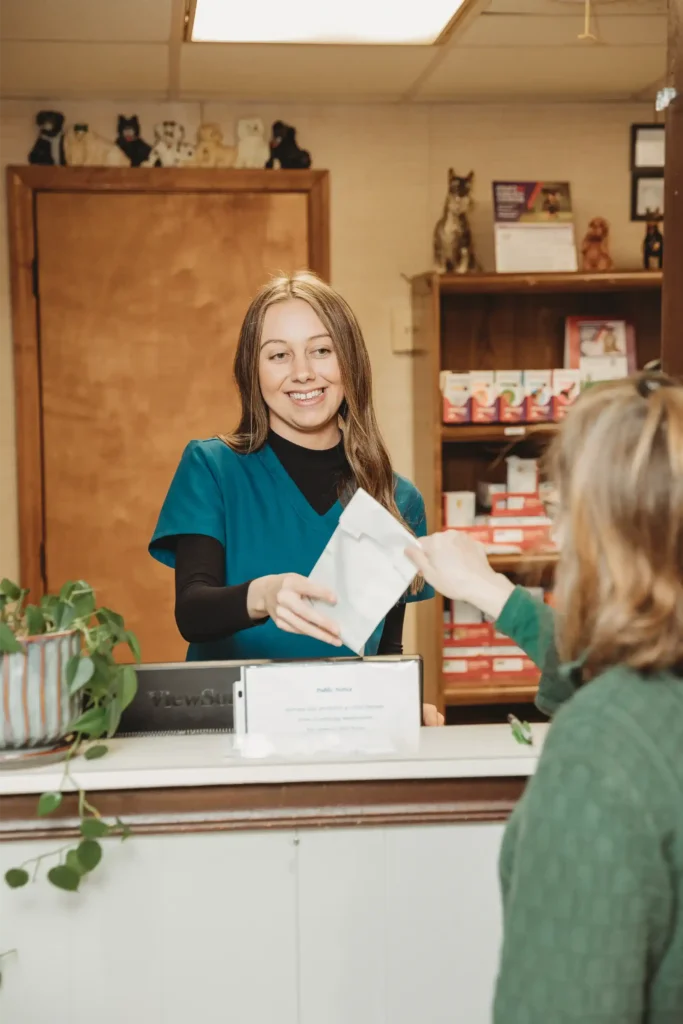 Veterinary staff member giving client flea and tick prevention medication